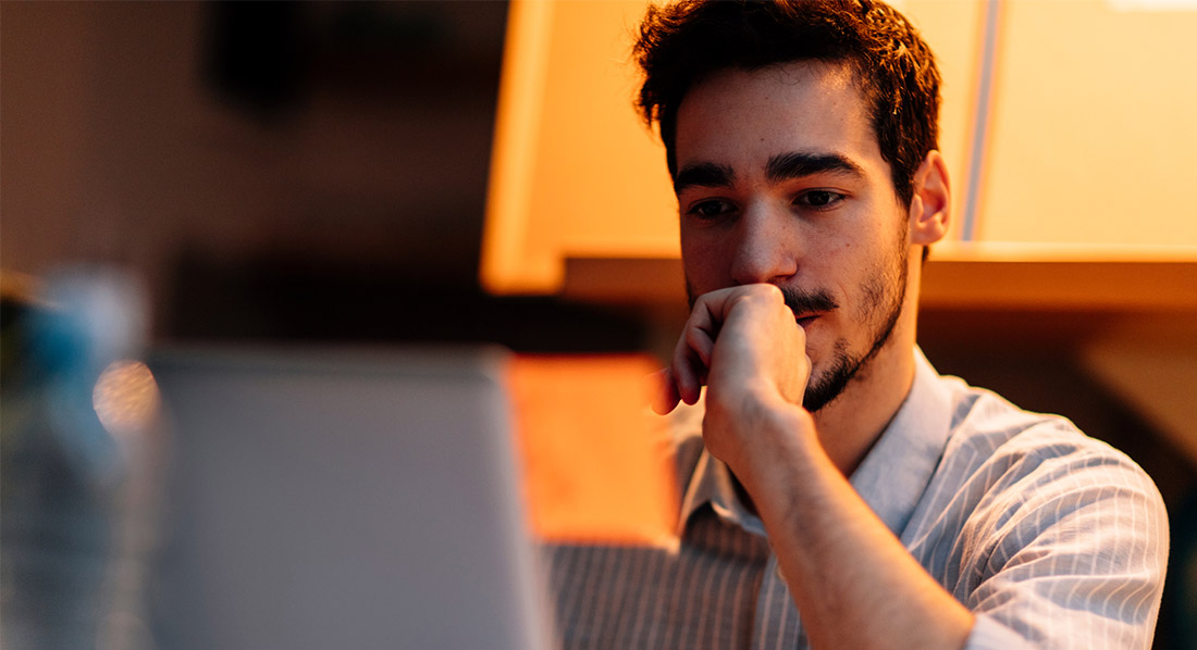 Traurig wirkender Mann schaut auf einen Computerbildschirm